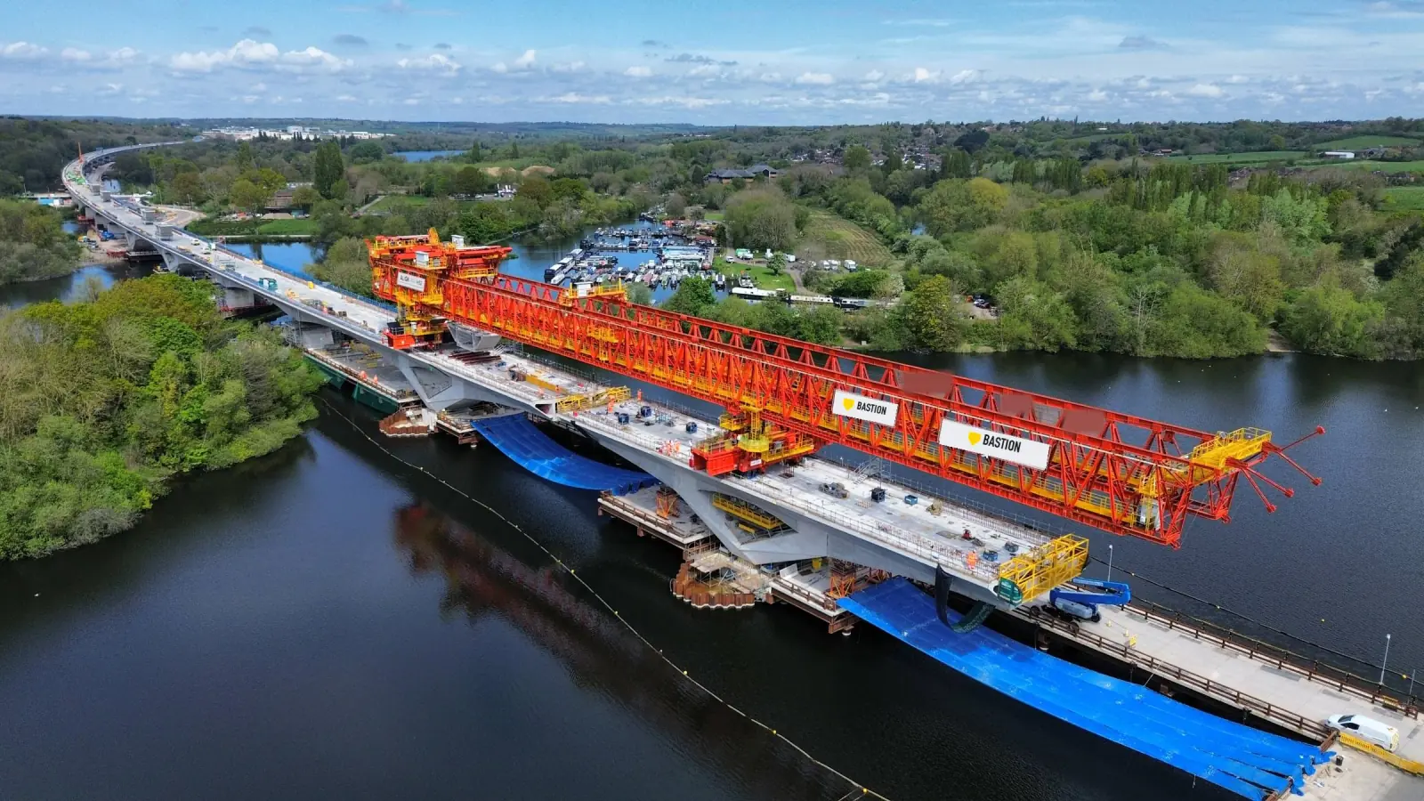 A launching girder placing deck segments on a viaduct across a lake